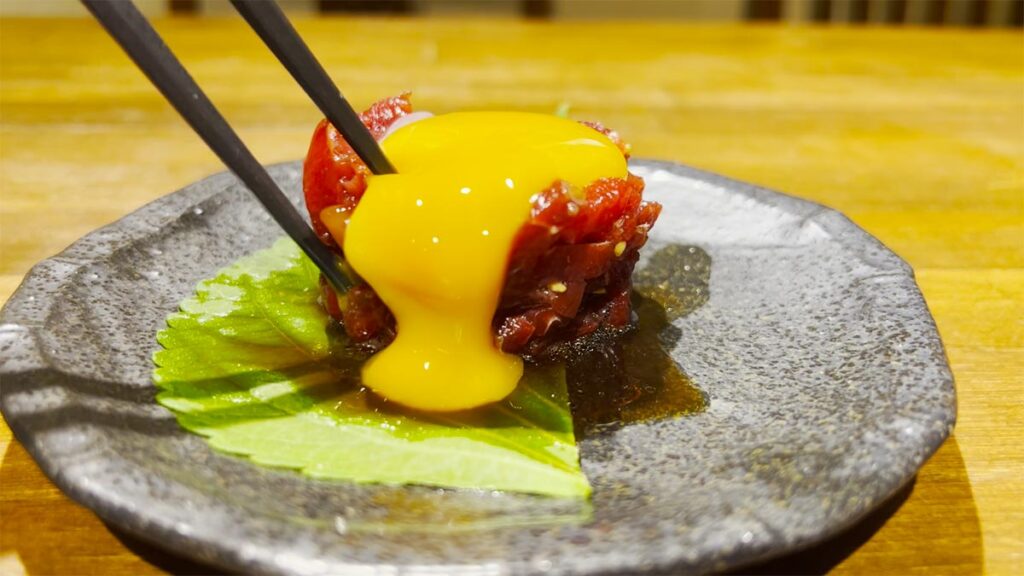 卵黄を絡めて食べる韓TARASHIの馬刺しユッケ